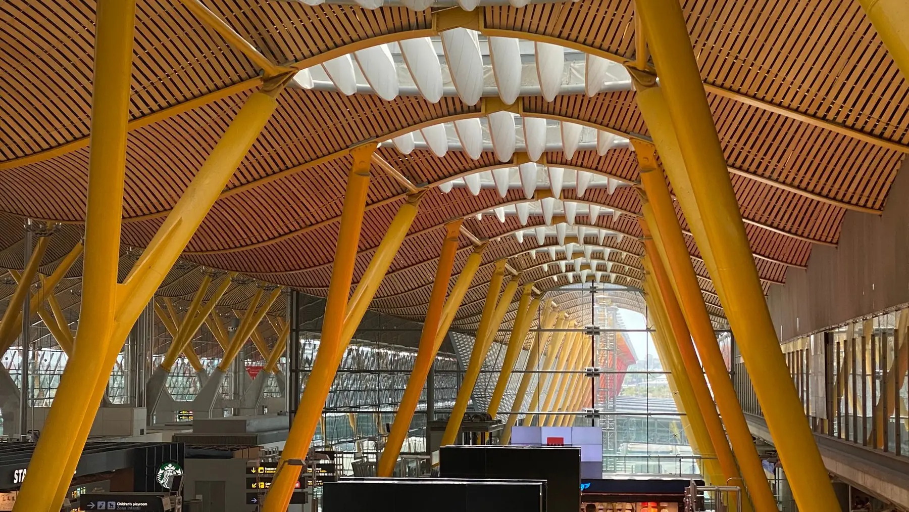 Vestíbulo de la terminal 4 del aeropuerto de Madrid-Barajas, con sus columnas amarillas y la cubierta de bambú