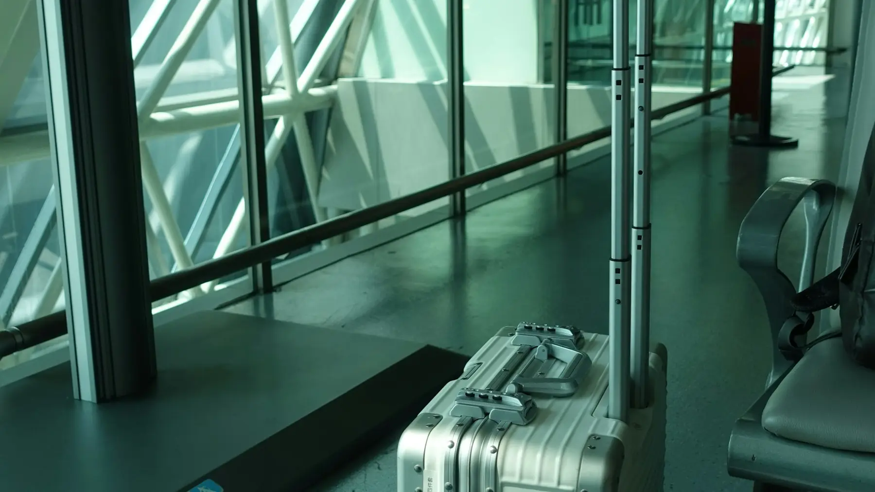 Maleta de cabina con el asa extendida en la terminal de un aeropuerto