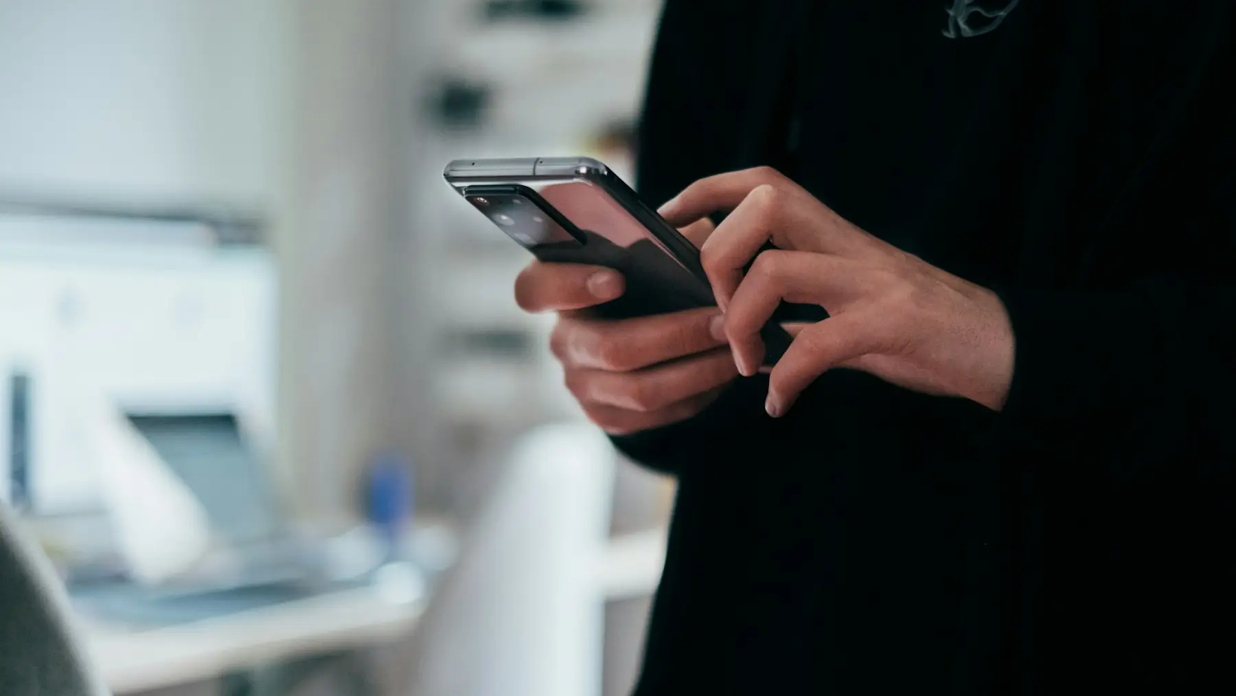 Persona sosteniendo un teléfono móvil en la mano