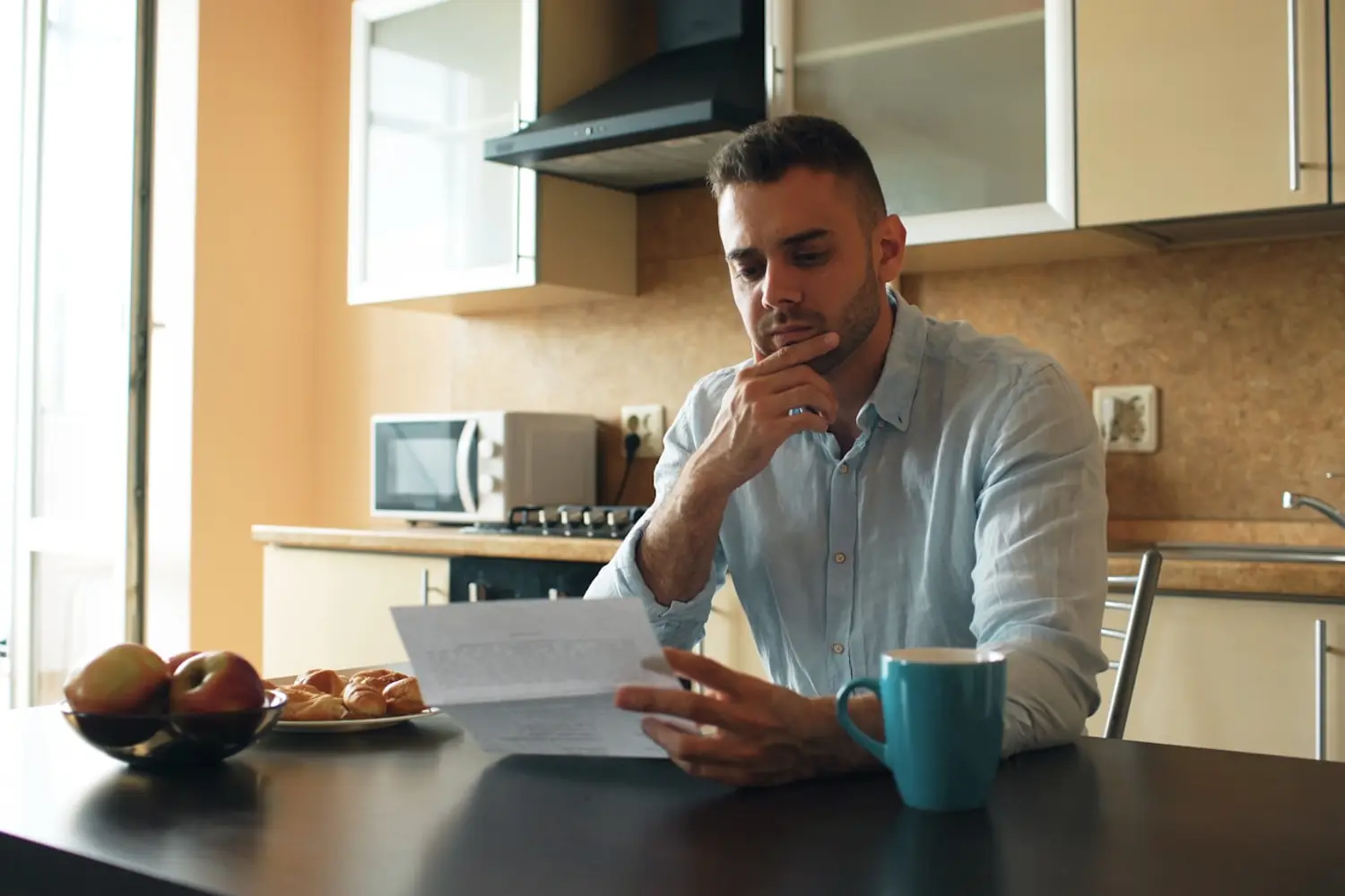 Persona revisando un documento sentada a la mesa de su casa